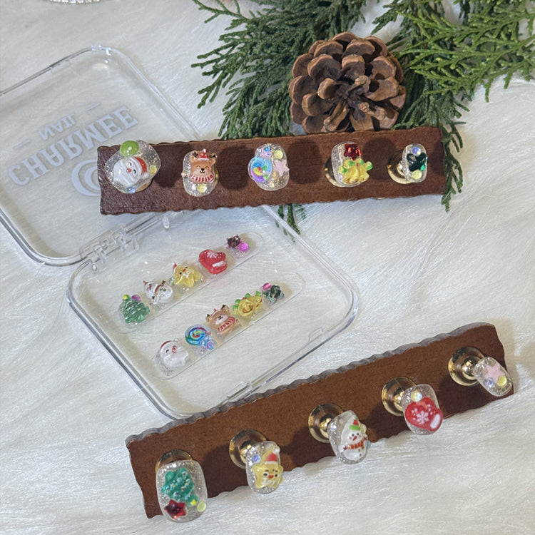 Handmade festive nails with glitter base and holiday icons like star, mitten, and candy