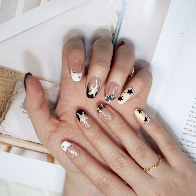 Trendy black and white star nails with marble effect and glossy finish