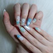 Ocean-inspired nails in blue and green with starfish and seashell designs