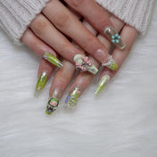 Kawaii green gradient nails with pearls, resin charms, and playful design