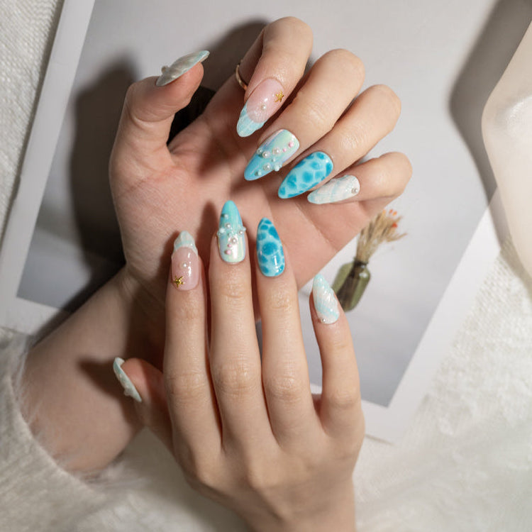 Mermaid style press-on nails with pearl accents and shimmering sea patterns