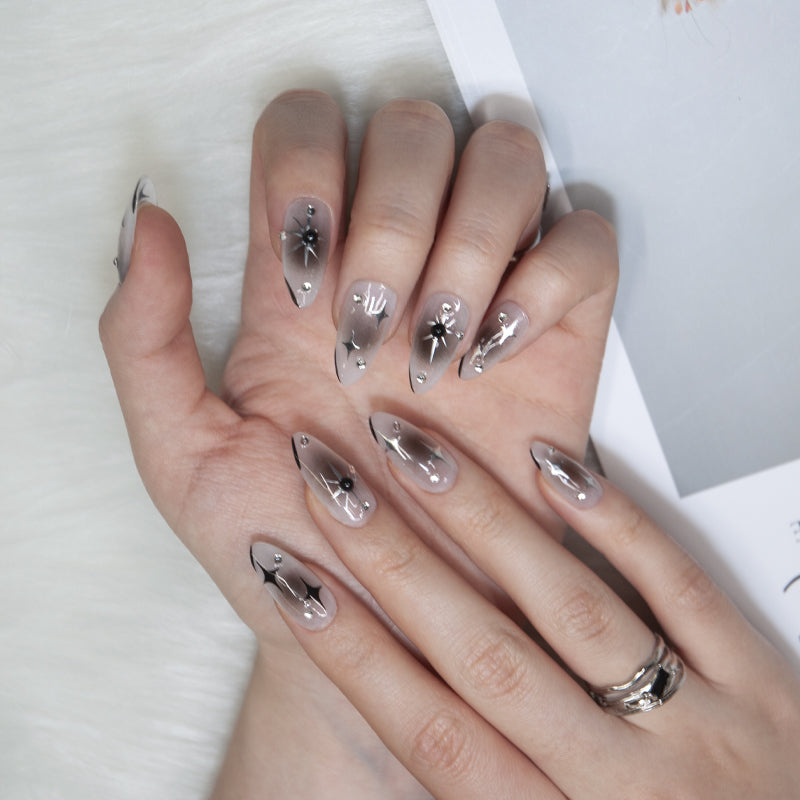 Almond nails with gradient design, silver stars, and crystal gems
