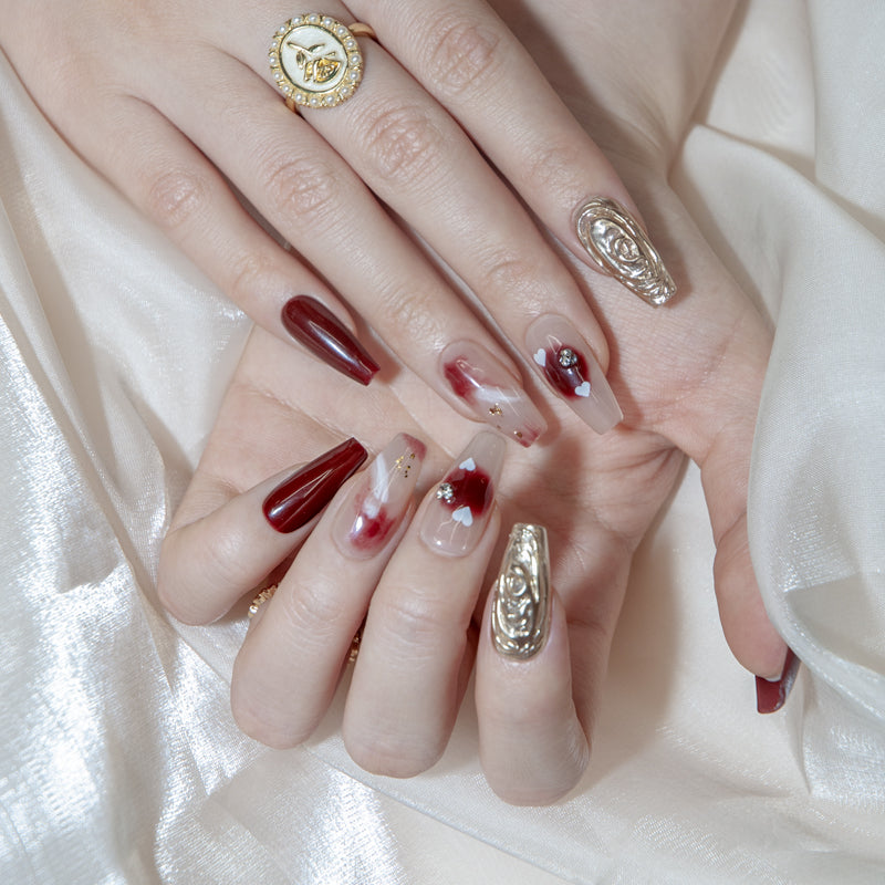 Romantic press-on nails with burgundy, nude marble, and metallic accents