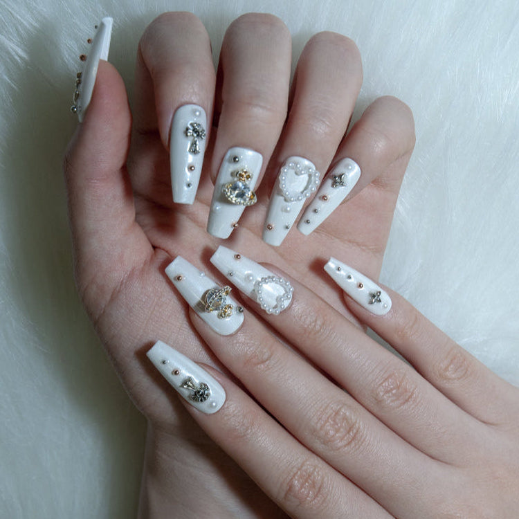 Luxury pearl white nails with mixed metallic studs and gemstone embellishments
