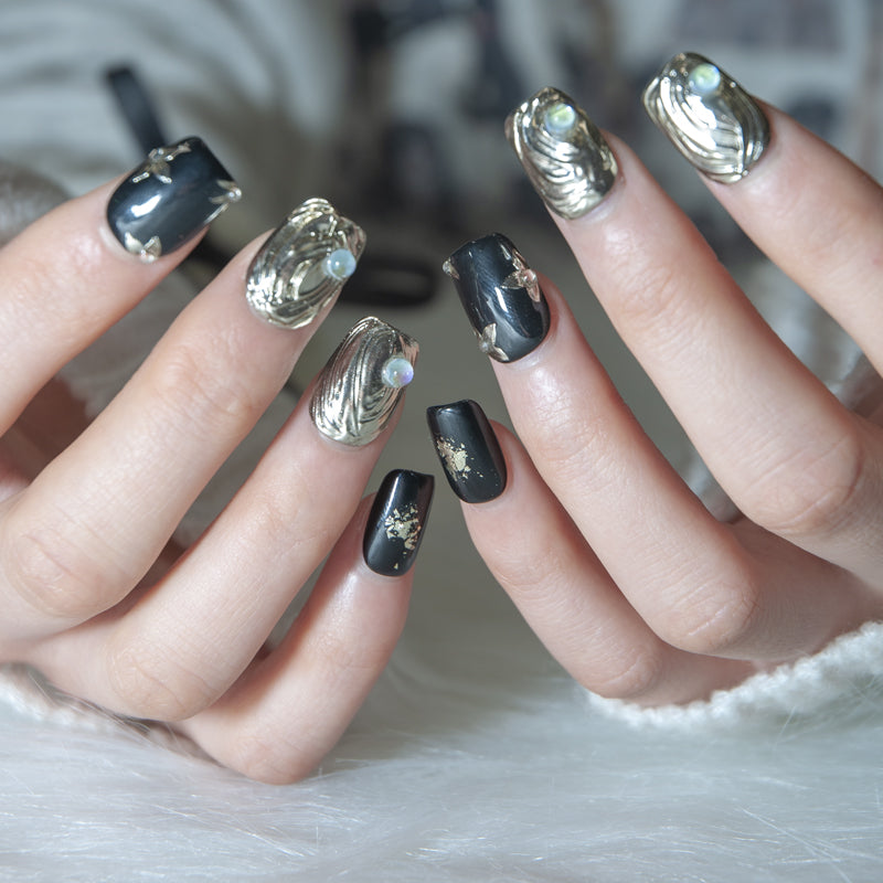 Luxury black press-on nails with metallic gold sculpted design and opal embellishments