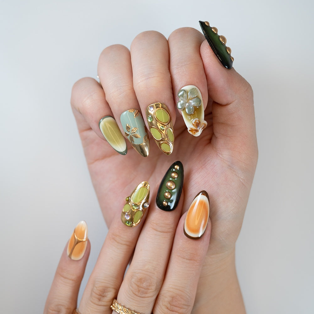 Olive green and orange press-on nails with gold details and gemstone designs