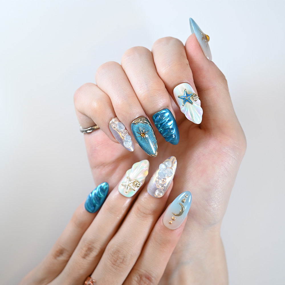 Handmade ocean-inspired nails with 3D starfish, pearls, and metallic shine