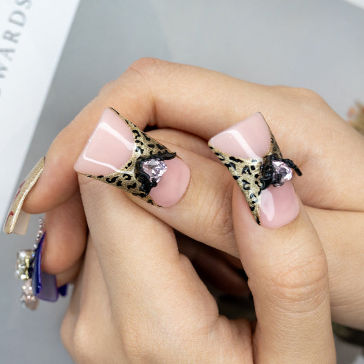 Glam leopard and purple press-on nails with heart-shaped gems and sparkle finish