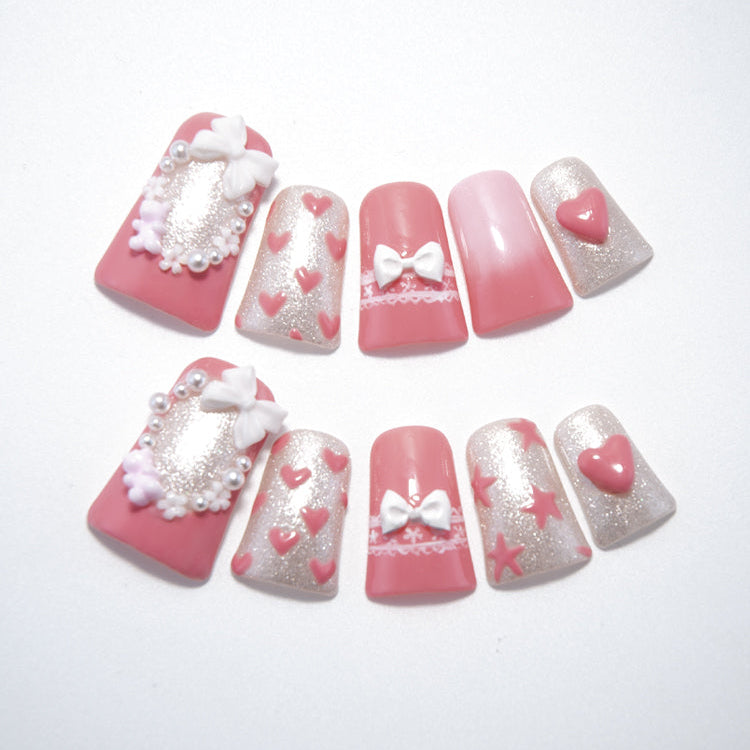 Pink bow press-on nails with pearl frame and glitter hearts