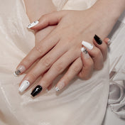 Minimalist black and white press-on nails with crescent moon art and gothic charm