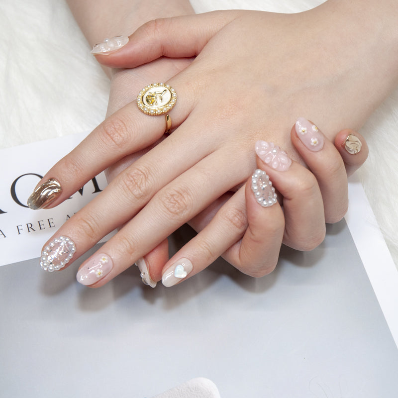 Handmade soft pink nails with pearl heart charm, daisy flowers, and glitter details
