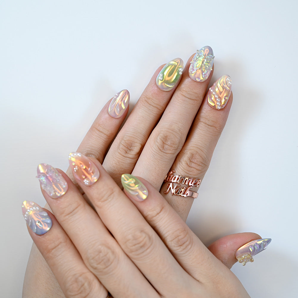 Luxury party nails with opal shimmer, pearl accents and intricate embossed patterns