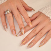 Astrology-inspired press-on nails with sun, moon, and constellation designs in gold