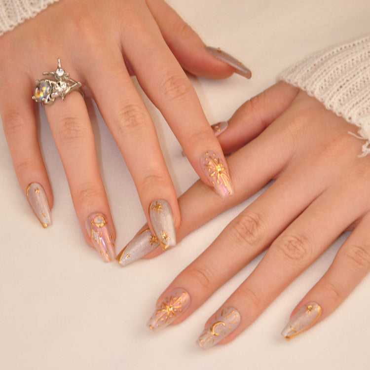 Astrology-inspired press-on nails with sun, moon, and constellation designs in gold