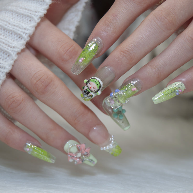 Cute handmade nails with lime green glitter, pearl beads, and character design