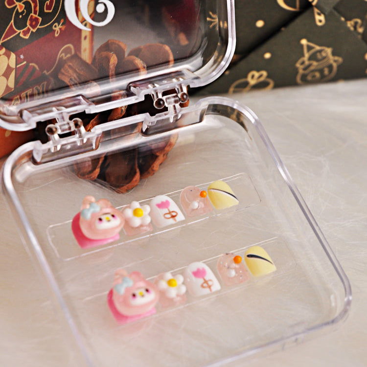 Playful press-on nails with pink bunny, tulip art, glitter, and pastel yellow design