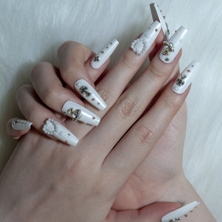 Elegant bridal press-on nails with silver cross, gold planet charm, and pearl accents