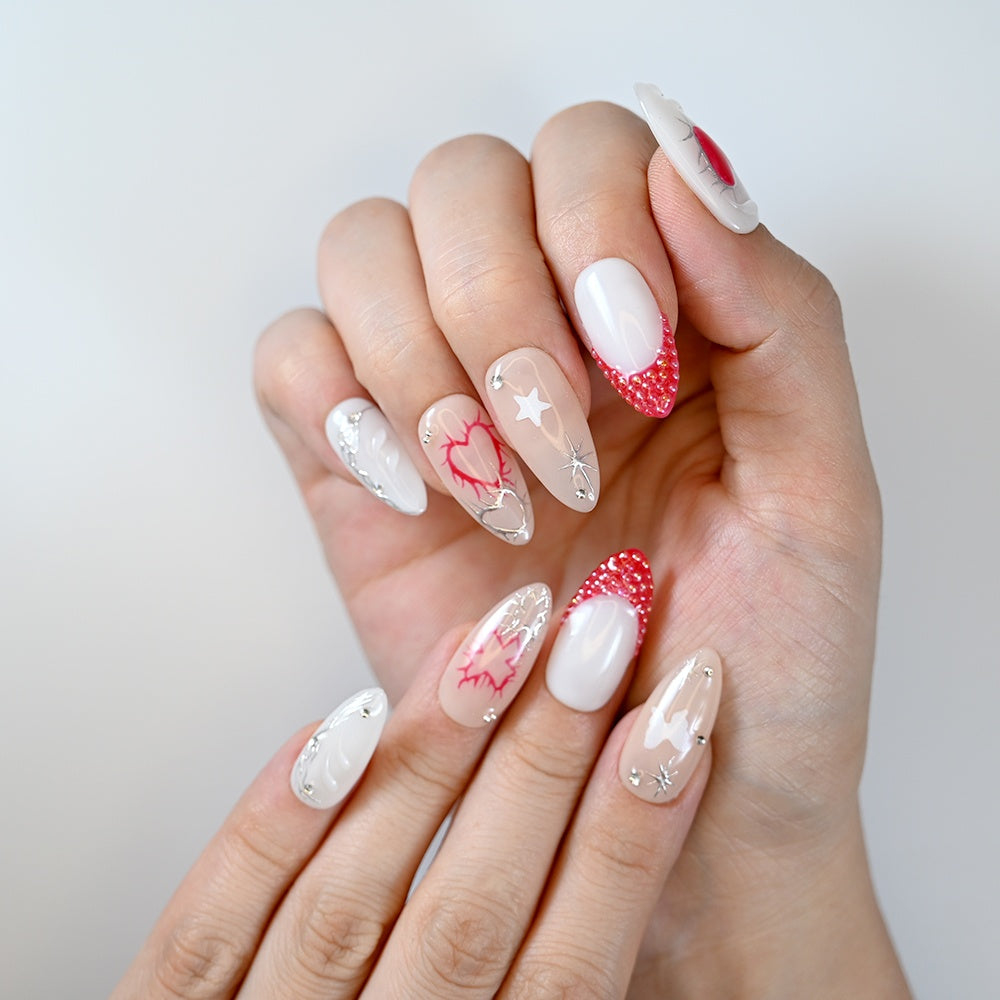 White almond press-on nails with red heart design, rhinestone accents and beaded French tips