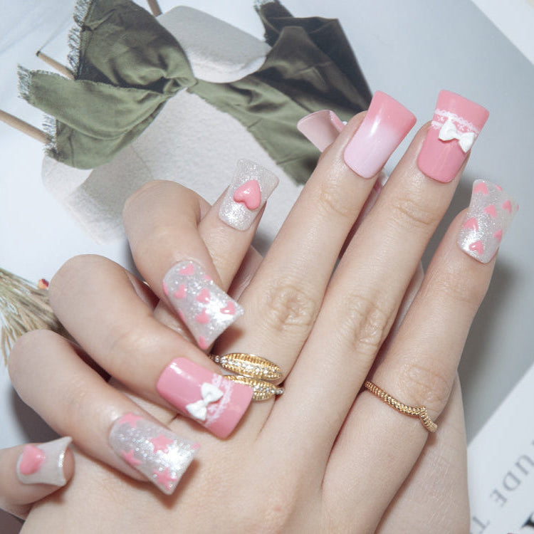 Romantic pink nails with 3D hearts, stars, and lace bow design