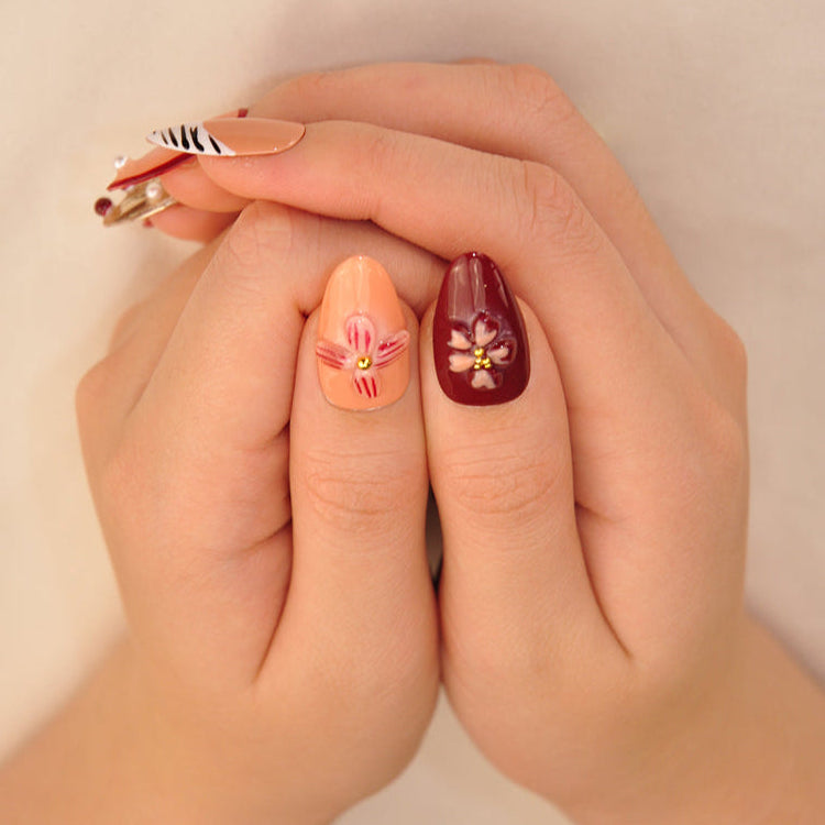 Elegant autumn style press-on nails with burgundy florals, gold details, and zebra print