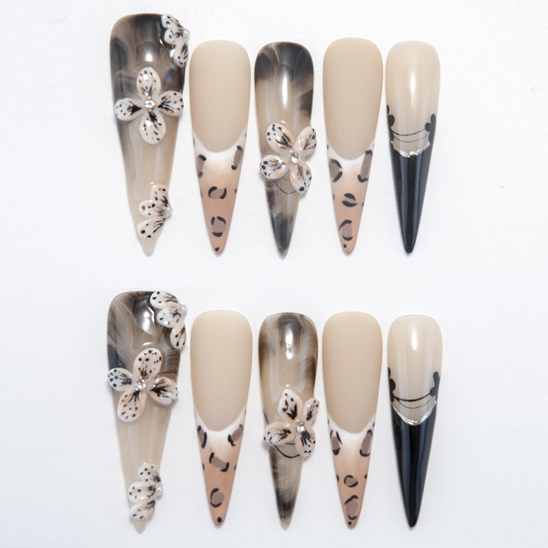 Long stiletto press-on nails with 3D leopard flowers, black tips, and nude base