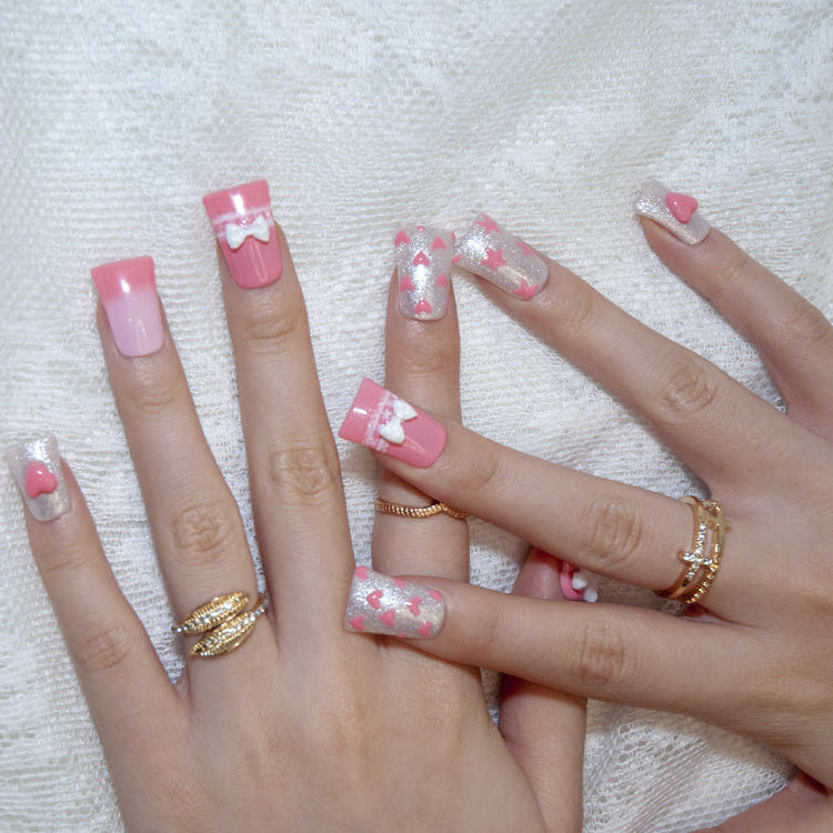 Cute pink and silver glitter nails with white bows and pearls