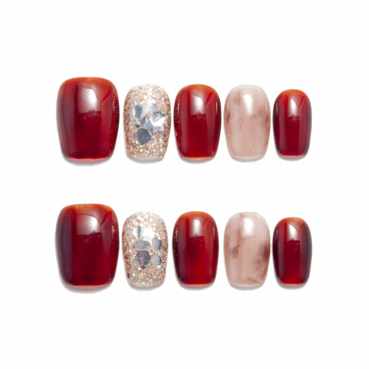 Short square press-on nails in wine red with marble beige and glittery gemstone design