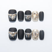 Matte black press-on nails with silver glitter tips and champagne gemstone accents