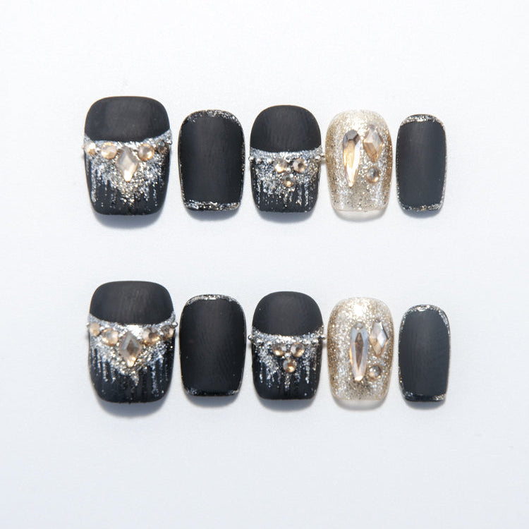 Matte black press-on nails with silver glitter tips and champagne gemstone accents
