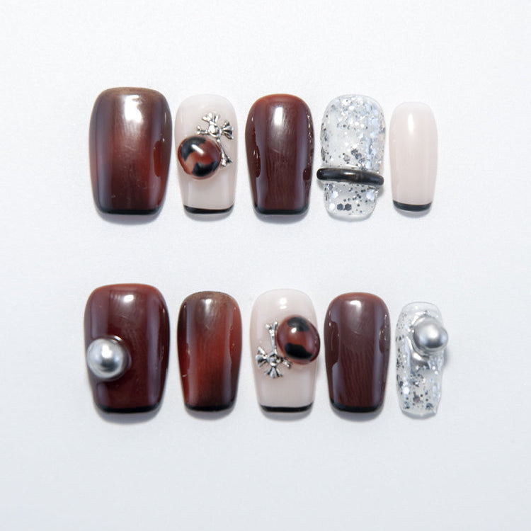 Burgundy press-on nails with gemstone accents and silver metallic details