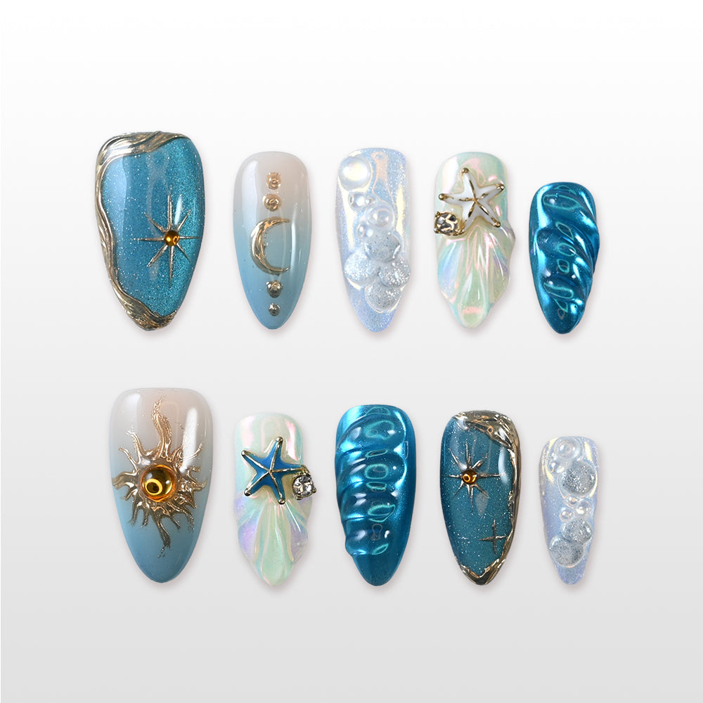 Blue and silver press-on nails with star, moon, and seashell accents