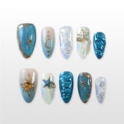 Blue and silver press-on nails with star, moon, and seashell accents