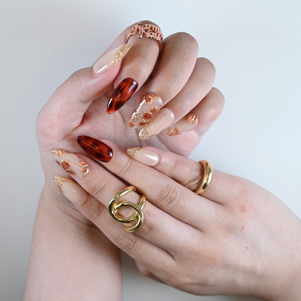  Elegant fall-inspired press on nails featuring brown jelly tips and gold leaf details