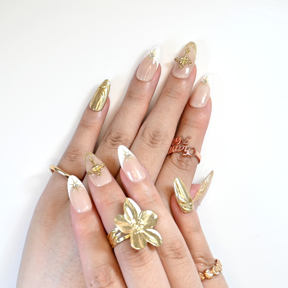 Handmade nude and gold nails with metallic textures and rhinestone star designs