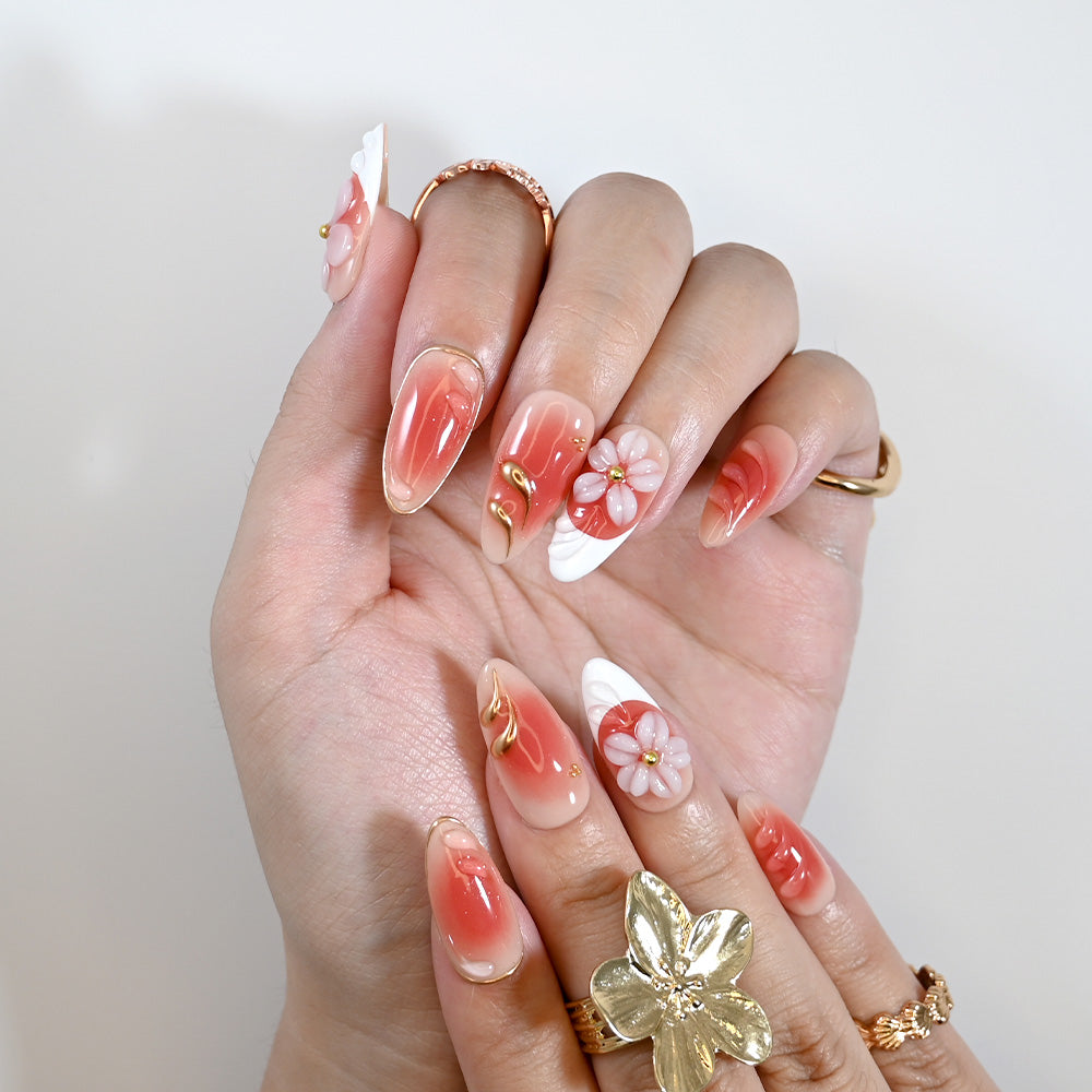 Handmade glossy nails with coral ombre, floral art, and gold metallic details