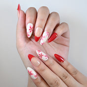 Medium almond reusable press-on nails with red tips and flower art details