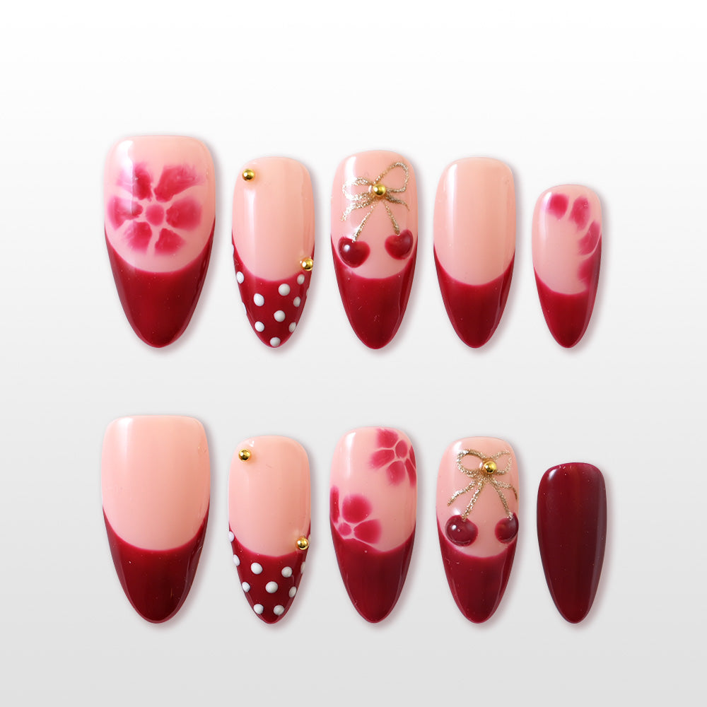 Red French tip press-on nails with cherry and bow accents