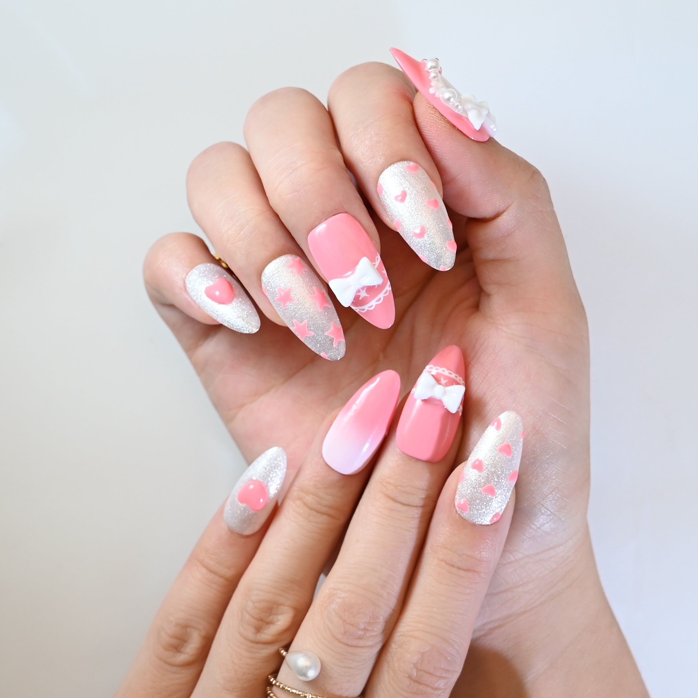 Romantic heart-pattern press-on nails in pink and silver glitter with 3D bow charms