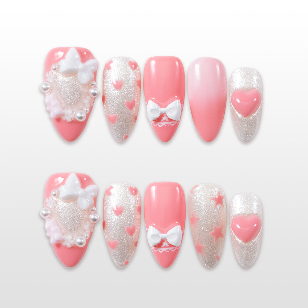 Cute press-on nails with pastel pink tips, 3D bows, glitter base, and pearl accents