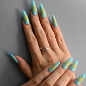 Beach-inspired gradient nails with blue sky and golden sand tones