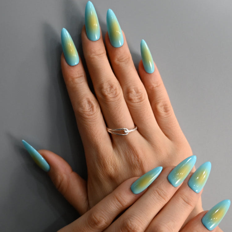 Beach-inspired gradient nails with blue sky and golden sand tones