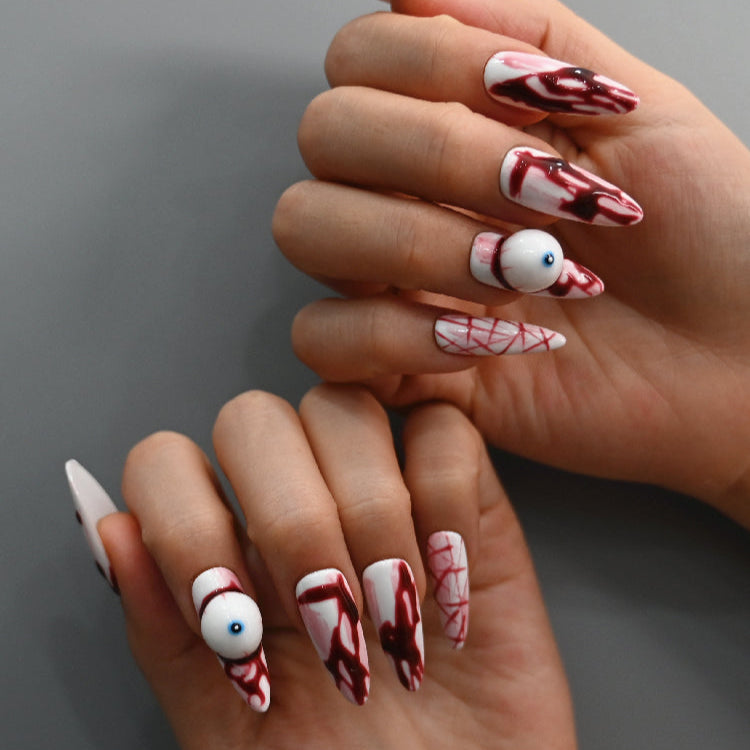 Horror themed press-on nails with dripping blood and spooky eyeball charm
