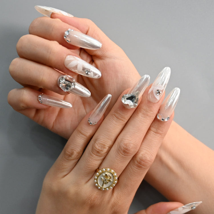 Elegant white floral press-on nails with heart-shaped crystal charm and silver gradient