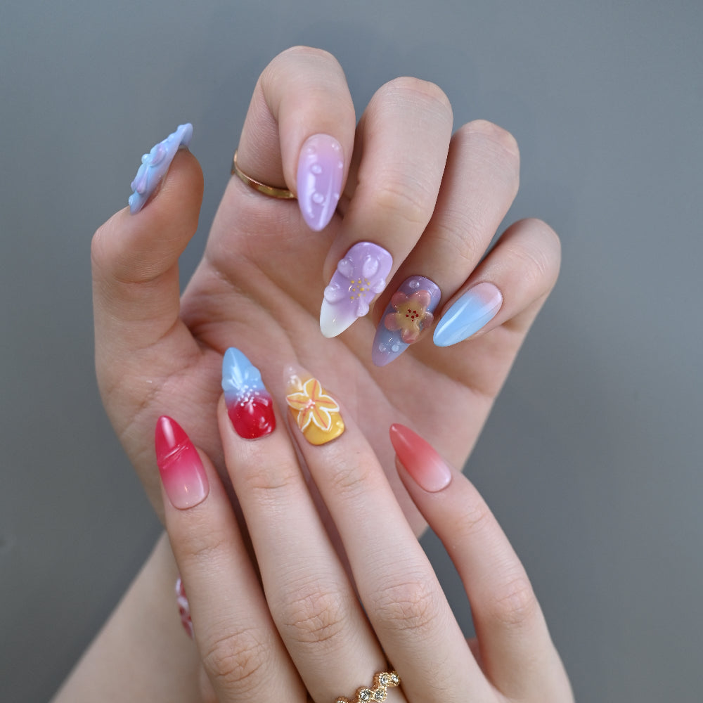Colorful ombre nails featuring purple, blue, pink, and yellow 3D flowers