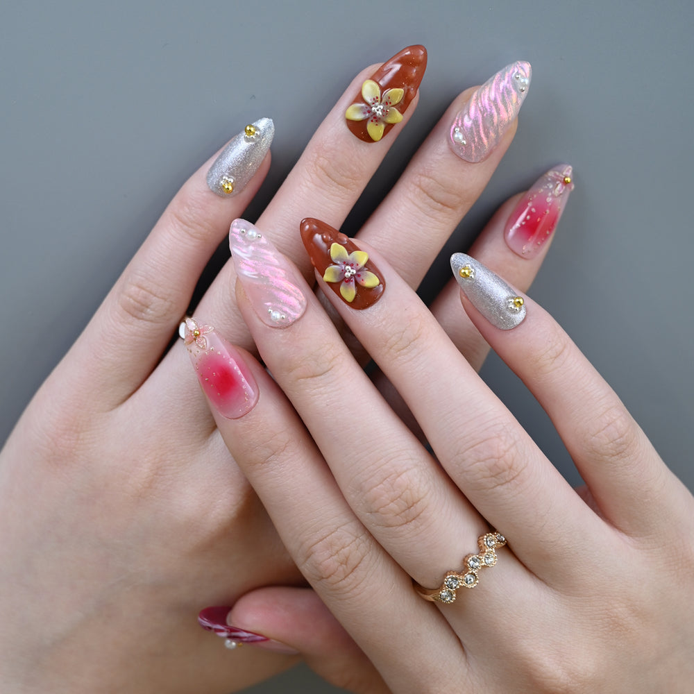 Handmade almond nails featuring ombre pink-red design, shimmer swirl, and flower