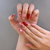 Cute cherry-themed press-on nails with red stars and pearl bow accents