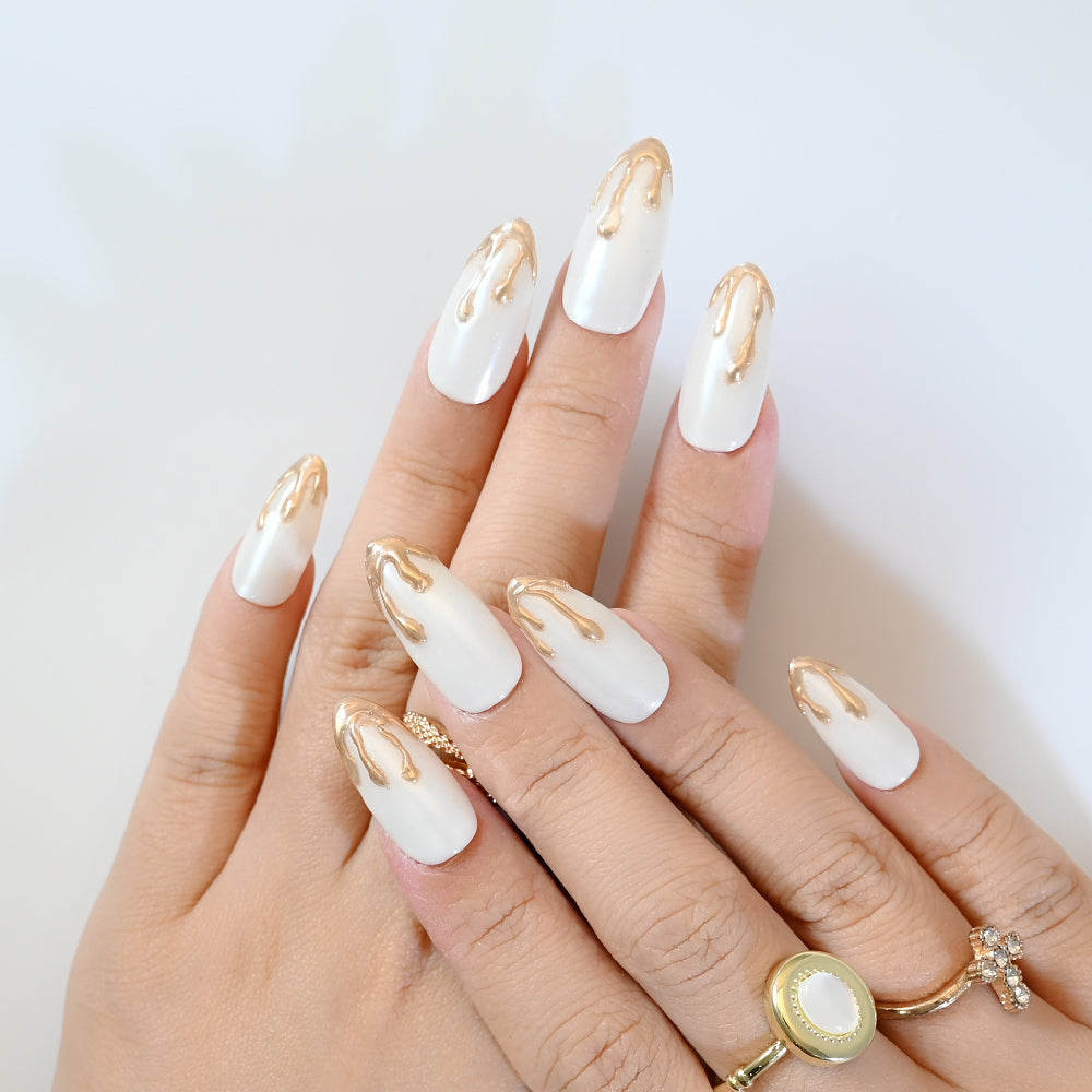 Elegant white and gold press-on nails with abstract molten metal tips