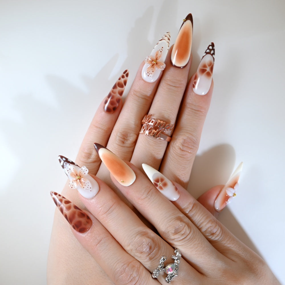 Brown and white press-on nails with artistic flower design and wild animal print