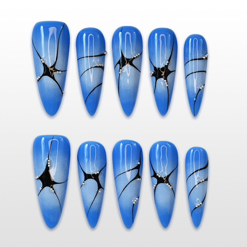 Long stiletto blue ombre press-on nails with black spider web design and rhinestones