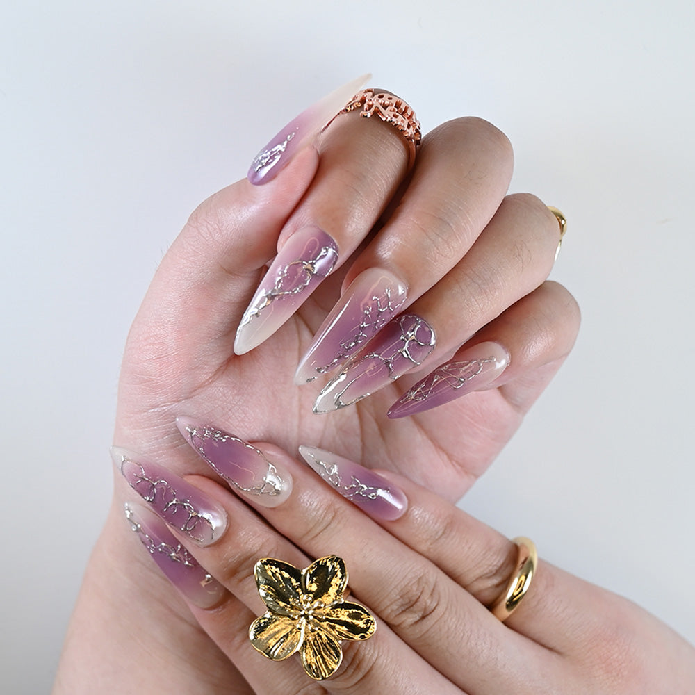 Handmade purple gradient nails featuring abstract silver foil accents